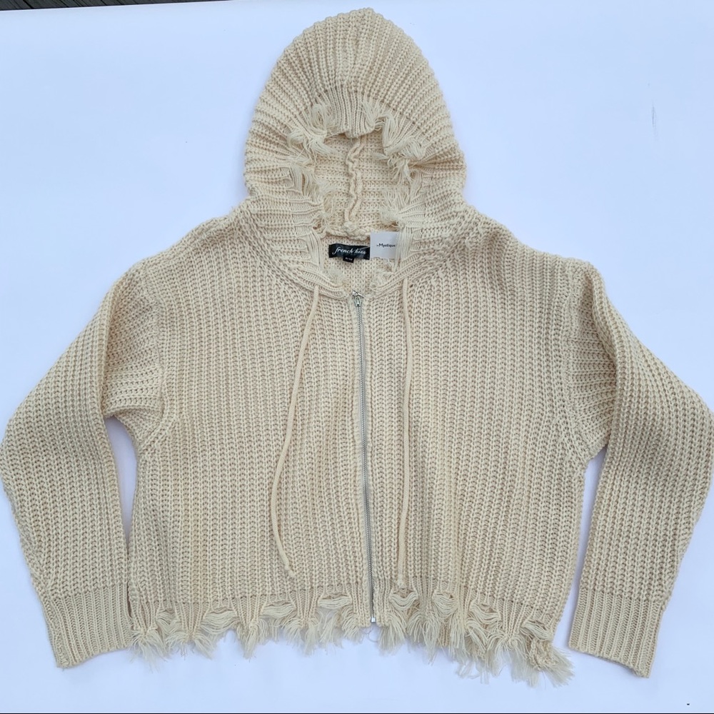 Cropped, cream colored, zip-up fringed sweater